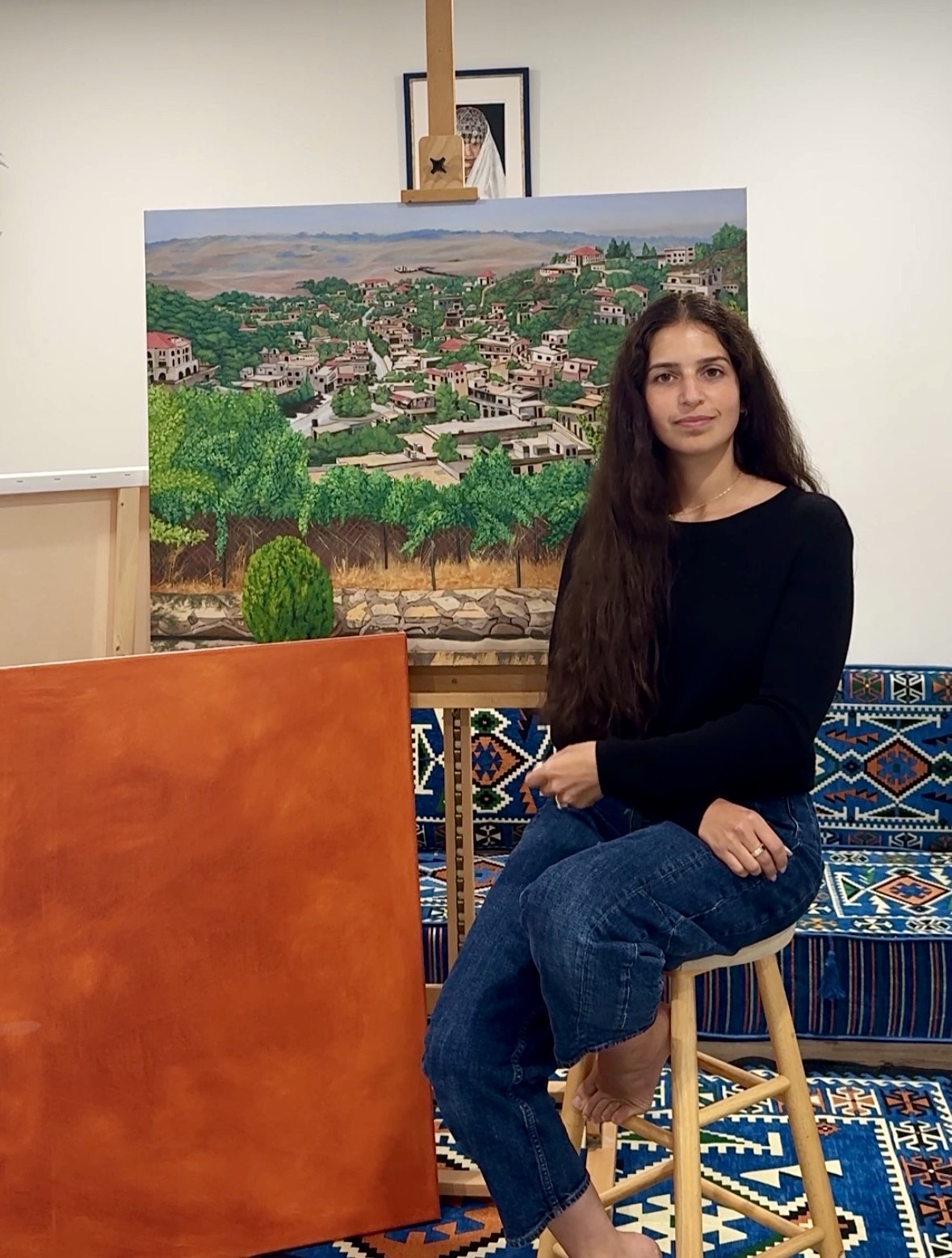 Meryem Berrada in her studio with a painting of Aït Ben Haddou